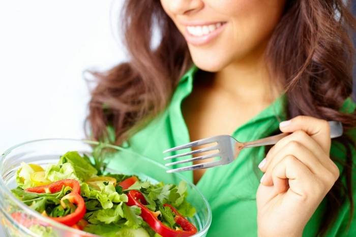 девушка ест салат из овощей